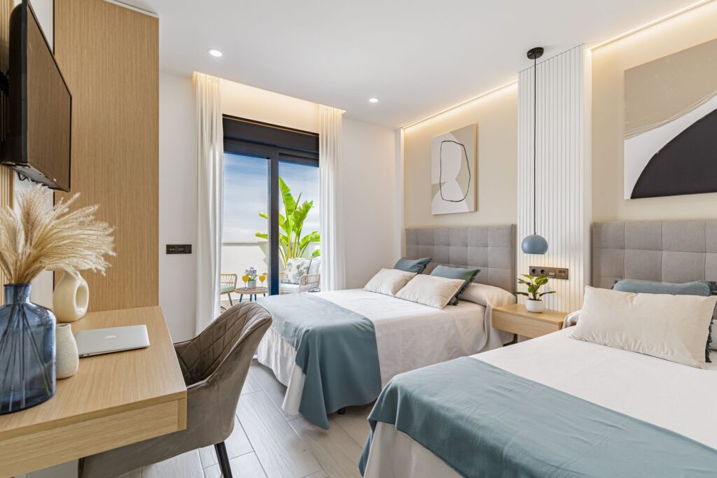 Habitación con balcón amplio, escritorio, tv de pantalla plana y dos camas de matrimonio. Elegante y luminosa.